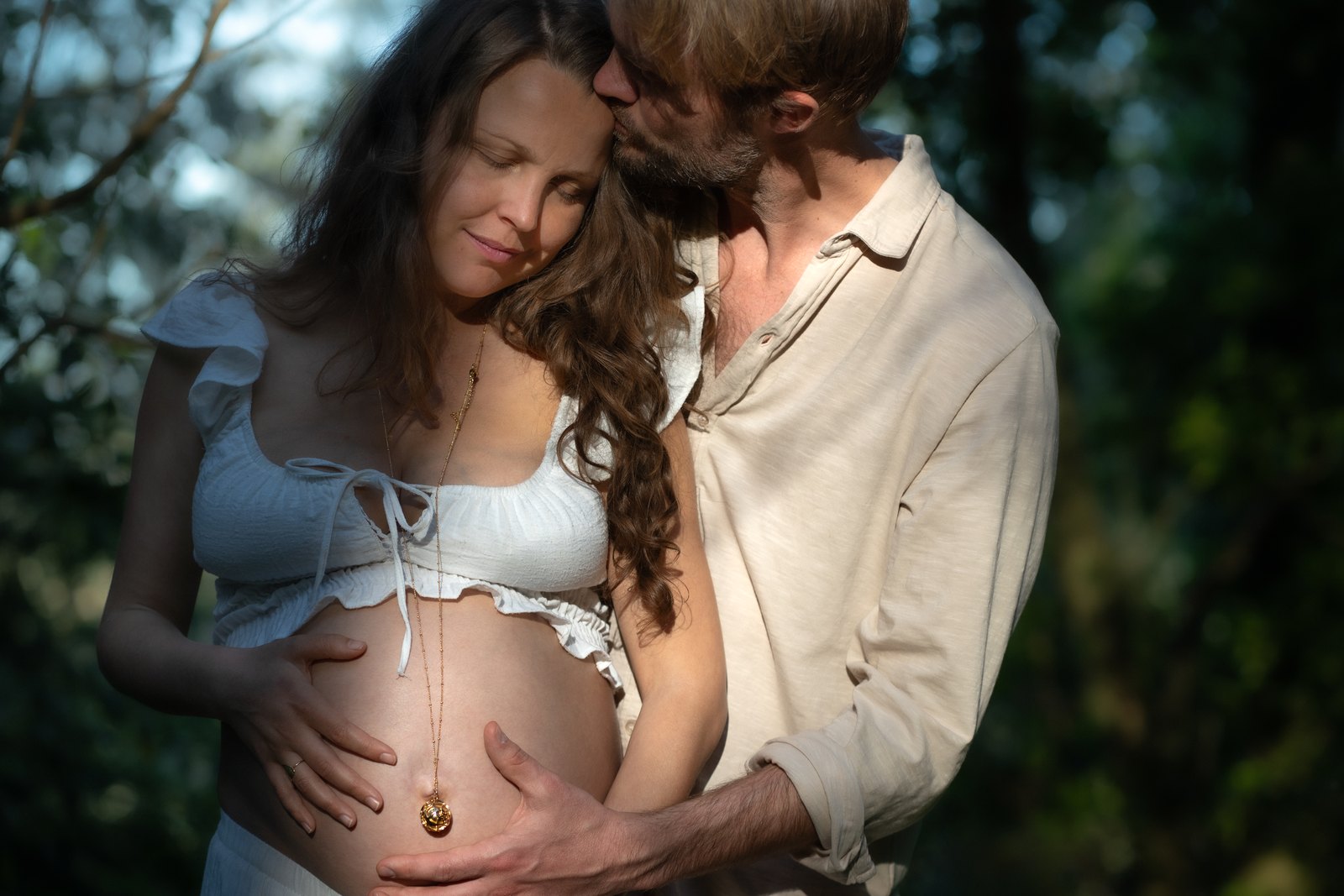 Expecting couple leaning together, eyes closed